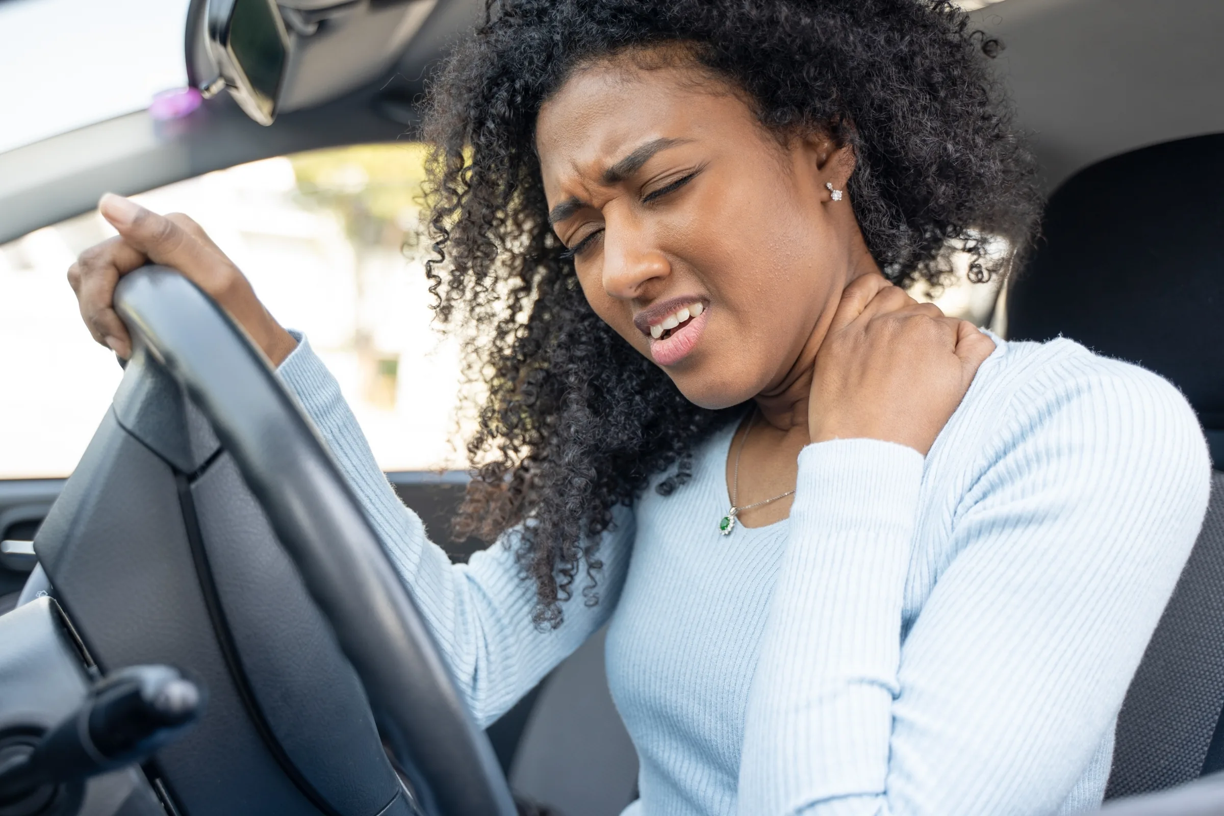 A driver holding her neck after a collision in Dumont