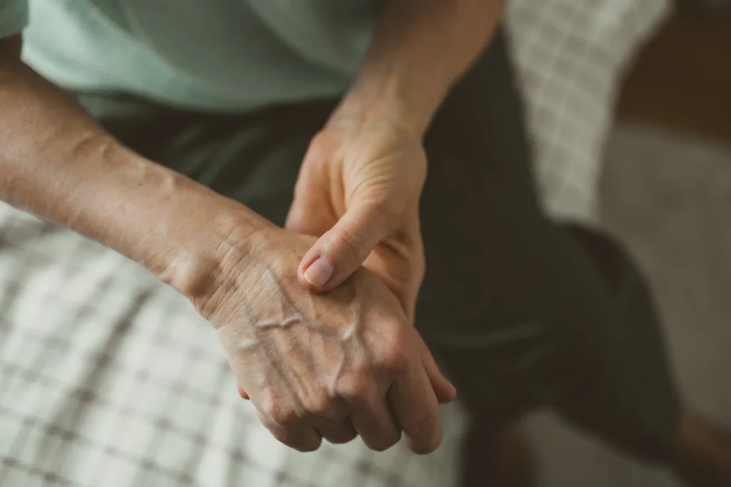Holding an aching, stiff hand where arthritis is felt