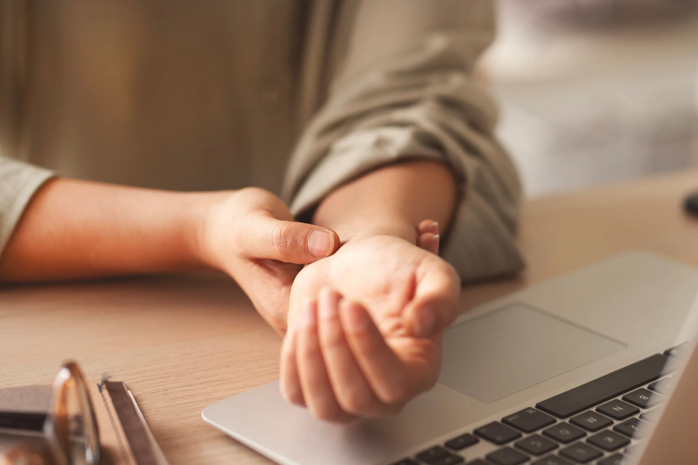 Holding a wrist where carpal tunnel numbness and tingling are felt