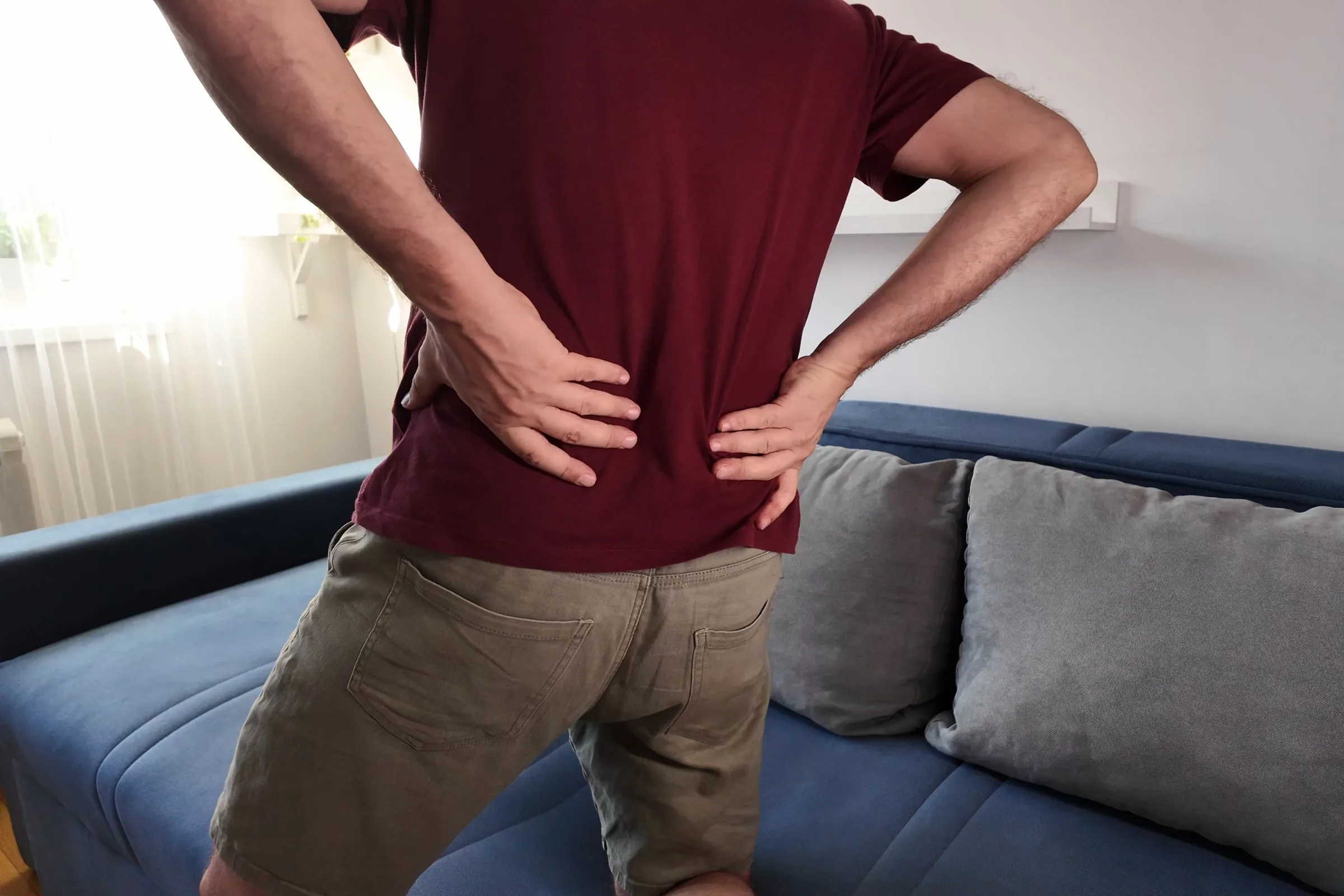 Hands to the low back, where a disc problem is usually first felt
